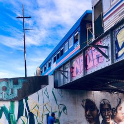 Low angle view of graffiti on building against sky