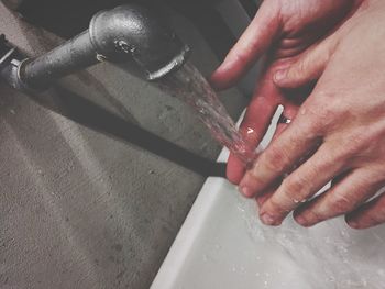Cropped image of person washing hands in sink