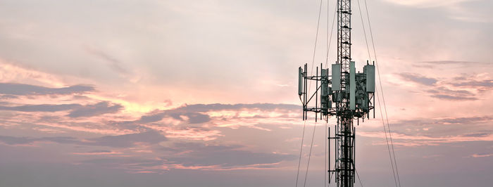 Low angle view of communications tower against sky during sunset