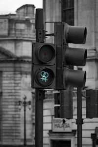 Close-up of road signal against buildings in city