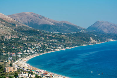 Scenic view of sea and mountains against blue sky