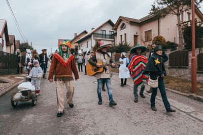 People on street against sky in city