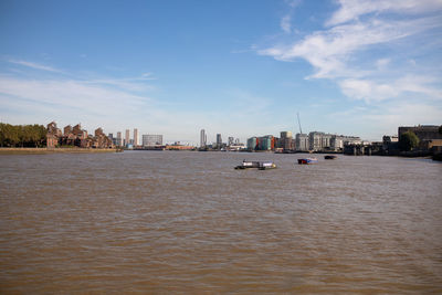 Sea by buildings against sky in city