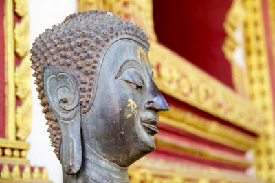 Close-up of buddha statue against building