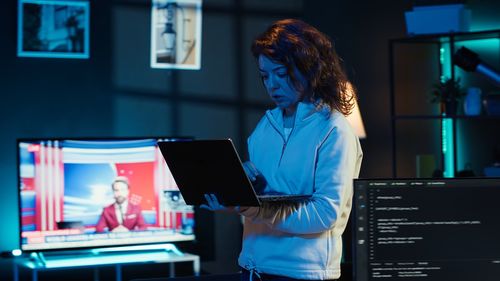 Young woman using laptop while sitting on table