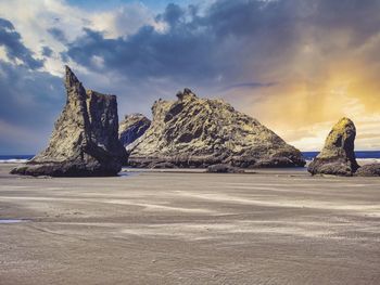 Rock formation on beach against sky