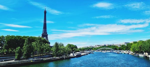 Buildings by river against sky