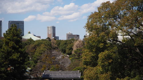 Low angle view of trees and buildings against sky