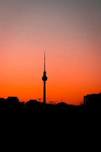 Silhouette of buildings against orange sky