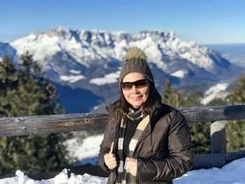 Portrait of young woman standing against mountain