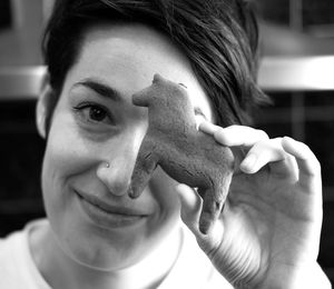 Close-up portrait of smiling woman holding baked horse cookie