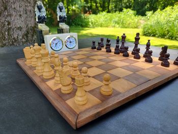 Close-up of chess pieces on table with egyptian status in the background