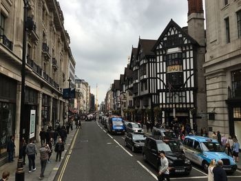 Cars on road in city against sky