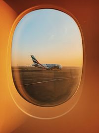 Airplane flying in sky seen through glass window