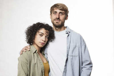 Portrait of young couple against white background