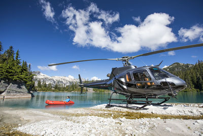 Helicopter pilot floats on lake under the tail of his helicopter