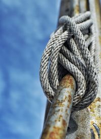 Low angle view of rope attached to rusty metal rod