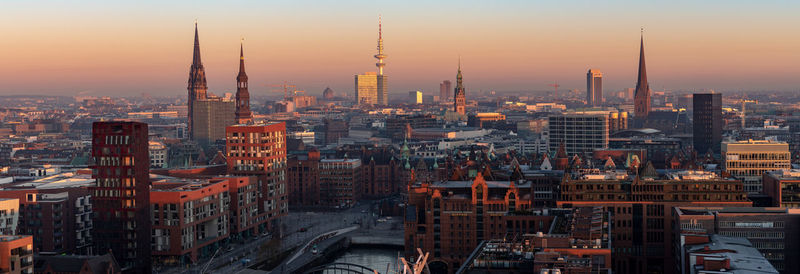 Aerial view of buildings in city during sunset