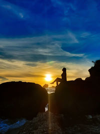 Silhouette rocks against sky during sunset