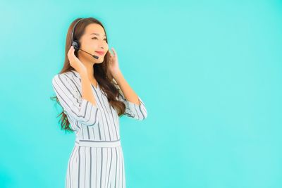 Woman standing against blue background