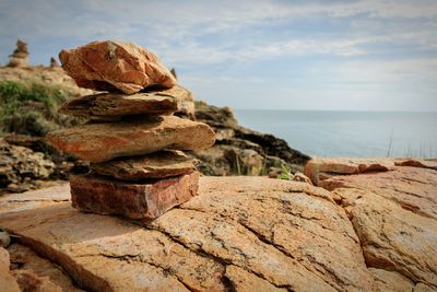 Stack of stones on beach against sky