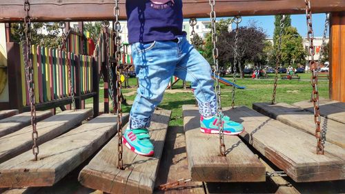 Low section of boy on play equipment at park