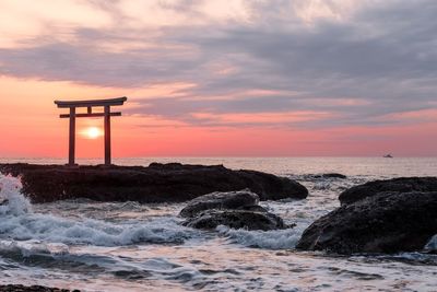 Torii gate at beach during sunset