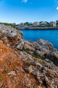 Rock formations by sea against sky