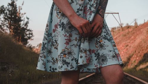 Midsection of woman standing on railroad track