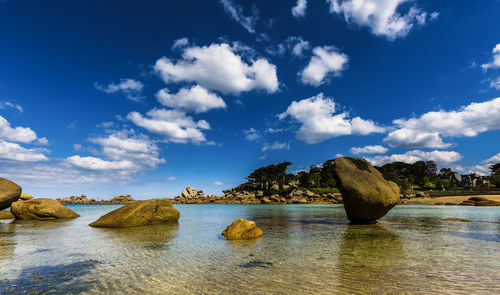 Rocks on shore against blue sky