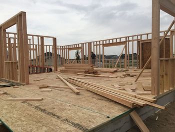 Wooden deck at construction site against sky