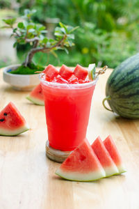 Watermelon juice in the glass on wooden table.