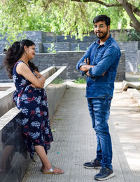 Indian couple posing for maternity baby shoot. the couple is posing in a lawn with green grass