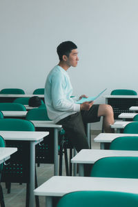 Young man using mobile phone while sitting on table