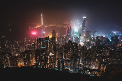 Illuminated buildings in city against sky at night