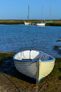 Boat moored at harbor against clear sky