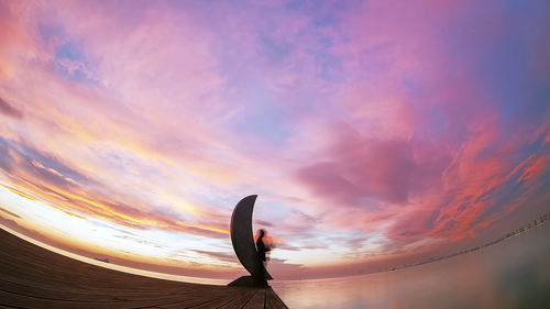 Low angle view of silhouette person against sky during sunset