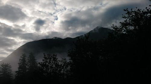 Low angle view of silhouette mountains against sky