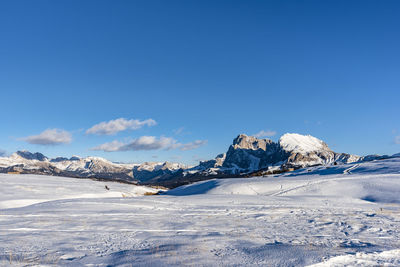 Scenic view of snowcapped mountains against blue sky