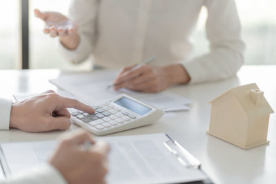 Midsection of woman working with smart phone on table