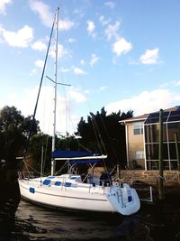 Sailboats moored in sea against sky