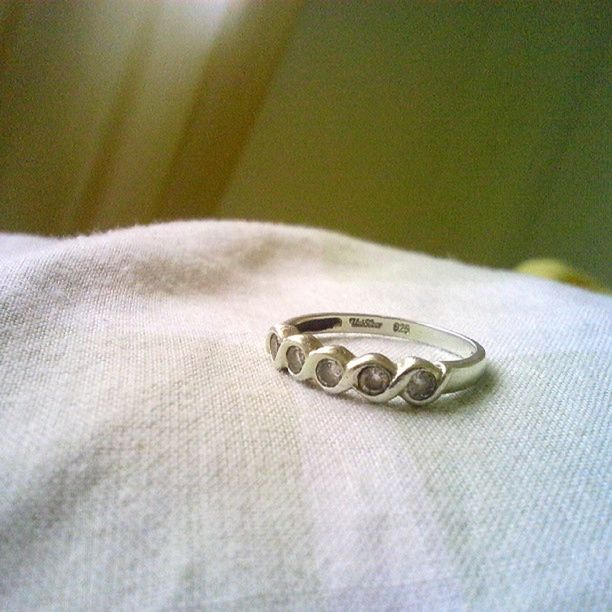 indoors, close-up, single object, still life, table, selective focus, high angle view, button, part of, number, personal accessory, old-fashioned, technology, connection, ring, jewelry, metal, time, no people, coin