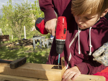 Full length of a boy holding wood