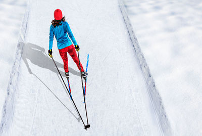 High angle view of woman skiing on snow covered field