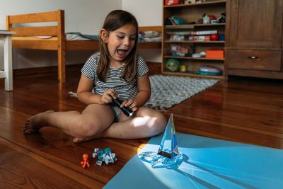 Portrait of boy sitting on floor at home