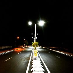 Road passing through illuminated tunnel