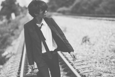 Businessman walking on railroad track