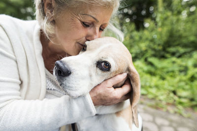 Happy senior woman cuddling her dog