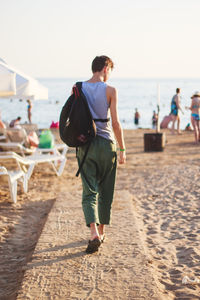 Rear view of man walking on beach