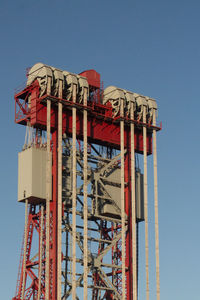 Low angle view of ferris wheel against clear blue sky